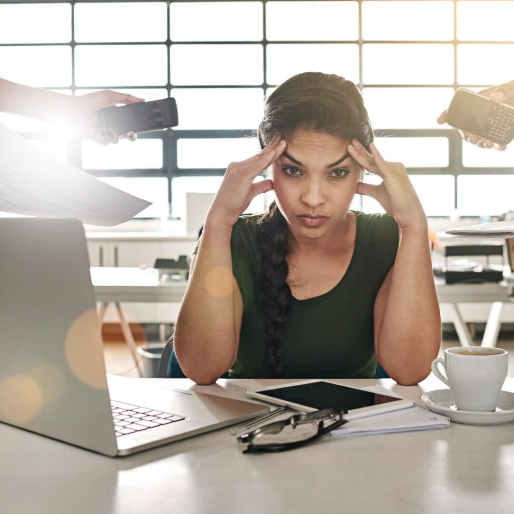 Young woman in front of computer, looking overwhelmed.